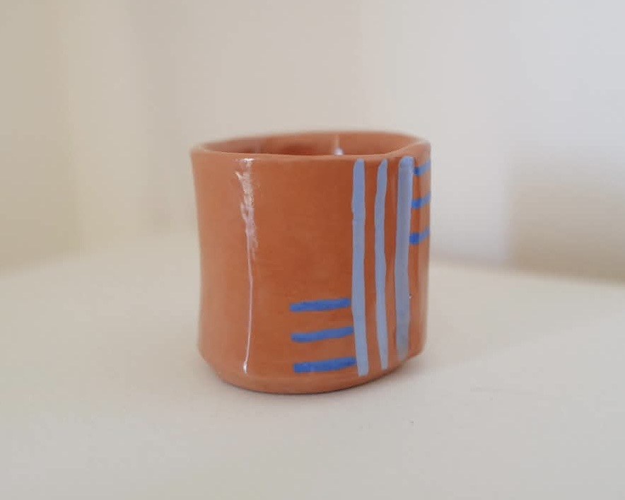 Terracotta cup with blue striped pattern