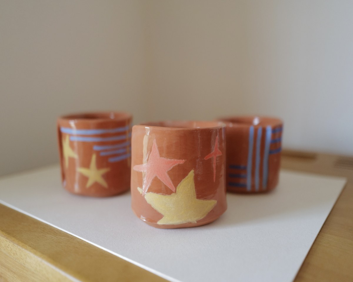 Three hand-painted terracotta cups together