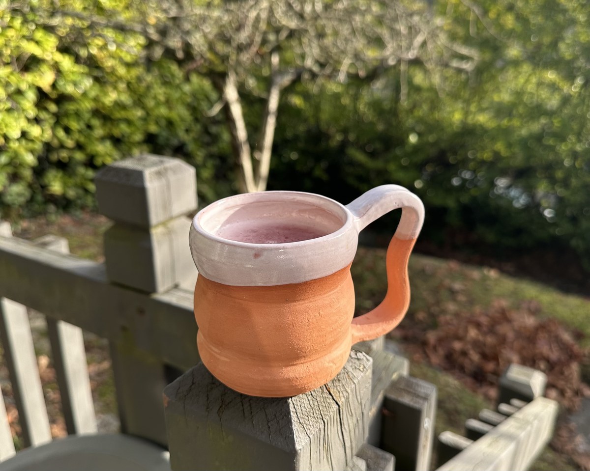 Terracotta mug with a pink and white glazed rim