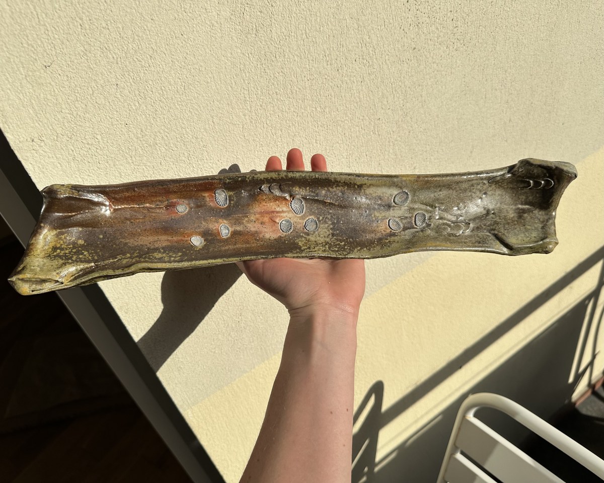 Long curved wood-fired serving tray with shell stamps